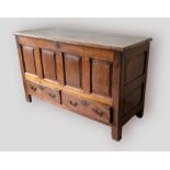 A George III oak mule chest, the hinged top above a four panel front and two drawers flanked by