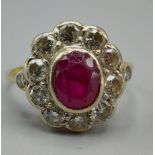 An 18ct gold ruby and diamond cluster ring, set with a central ruby surrounded by diamonds and