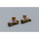 A pair of 9ct gold drop earstuds, each set with three green stones