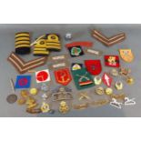 A small collection of military cloth and cap badges and a collection of other related items