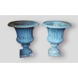 A pair of 19th Century cast iron garden urns of reeded flared form with square pedestal bases, 76cms