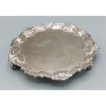 A Victorian silver letter salver with shape outline raised upon three scroll feet London 1900,