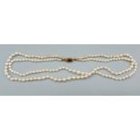 A graduated double row pearl necklace with 9ct gold garnet set clasp
