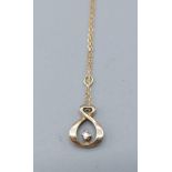 A 9ct gold diamond set pendant of scroll form with linked neck chain, 1.3gms