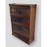A Globe Wernicke mahogany three section bookcase, with three sections above a drawer, 87cms wide,