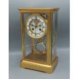 A late 19th Century brass cased library clock, the enamel dial with Roman numerals and two train