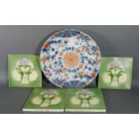 A set of four early 20th Century pottery tiles together with a Japanese dish