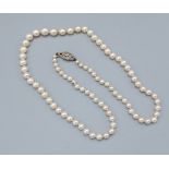 A single row graduated pearl necklace with 9ct white diamond set clasp, 55cms long