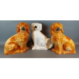 A pair of Staffordshire models of dogs together with another similar