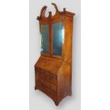 A George I walnut and herringbone inlaid bureau bookcase, the swan neck pediment above two