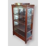 A 19th Century Continental mahogany display cabinet with a single glazed door enclosing shelves