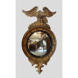 A 19th Century gilded convex wall mirror with eagle cresting, 57cms x 102cms