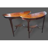 A pair of Edwardian mahogany console tables of demi-lune form with inlaid tops above an undertier