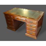 An Edwardian mahogany twin pedestal desk, the tooled leather inset top above nine drawers with brass