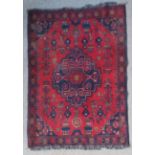 A Northwest Persian woollen rug with an all-over design upon a red and blue ground within multiple