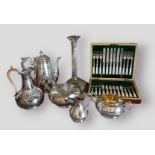 A silver plated candlestick of Corinthian form together with a three piece tea service, two hot