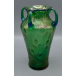 A Loetz style green iridescent glass vase of tapering dimple form with four handles, 18cms tall