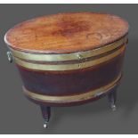 A George III mahogany and brass bound wine cooler of oval form, the hinged top above side carrying