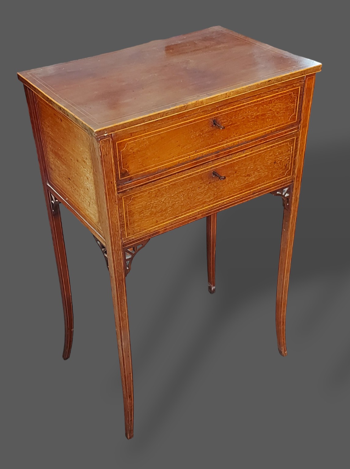 An Edwardian mahogany and satinwood inlaid work table with two drawers raised upon square tapering