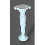 A painted wooden torchere, the shaped top above a turned column with circular base, 88cms tall