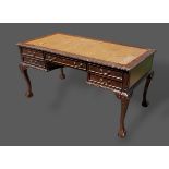 A mahogany library table, the tooled leather inset top above five drawers with brass handles and