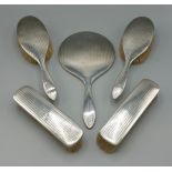 A Chester silver five piece dressing table set, comprising of four brushes and a hand mirror all