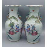 A pair of Canton vases decorated in polychrome enamels and highlighted with gilt with figures