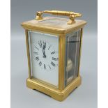 A brass cased carriage clock with lever escapement and carrying handle, 14cms tall