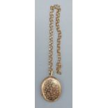 A 9ct gold pendant locket with engraved decoration together with a 9ct gold linked chain, 18.9gms
