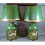 A pair of Toleware table lamps, each decorated with an armorial crest on a green ground and with