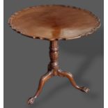 A mahogany pedestal table with a moulded top above a turned centre column raised upon ball and