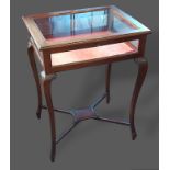 An Edwardian mahogany bijouterie, the hinged top above cabriole legs with crossover stretcher, 50cms