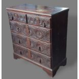A 19th Century oak chest of two short and three long carved drawers with drop handles, raised upon