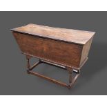 A George III elm dough bin with hinged top raised upon turned legs with stretchers, 125cms wide,