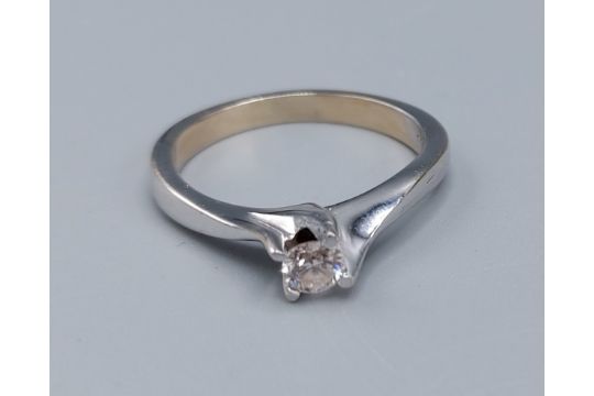 An 18ct white gold solitaire diamond ring, set with a single diamond within a crossover setting,