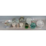 A large glass dump weight together with another similar and a collection of glassware