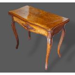 A Victorian walnut card table, the hinged top above a shaped carved frieze, raised upon cabriole