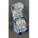 A 19th Century Delft character jug decorated in underglaze blue in the form of a seated lady,