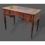 A William IV mahogany writing table with four drawers with circular brass handles raised upon