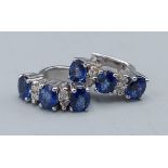 A pair of 18ct white gold diamond and sapphire set earstuds, each set with three sapphire and four