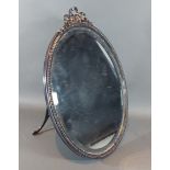 An early 20th Century silver plated oval table mirror with bow cresting, 46cms x 31.5cms