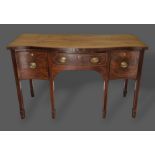 A 19th Century mahogany serpentine sideboard with a central drawer flanked by cupboards and raised