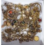 A collection of gold plated jewellery to include a fringe necklace, various chains and brooches