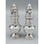 A pair of Birmingham silver salt and peppers of tapering form, 10cms tall