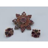 A garnet set brooch of star form together with a pair of Amethyst set ear studs
