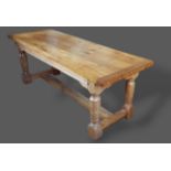 An oak refectory style dining table, the thick plank top above a reeded frieze raised upon turned