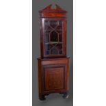 An Edwardian mahogany marquetry inlaid standing corner cabinet, the moulded top above an astragal