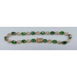 A 9ct gold linked bracelet set with green Topaz, 5.9gms