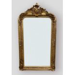 A gilded over mantle mirror with shaped cresting and foliate decorated frame, 155cms by 85cms