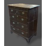 A George III oak chest, the moulded top above three short and three long drawers raised upon bracket